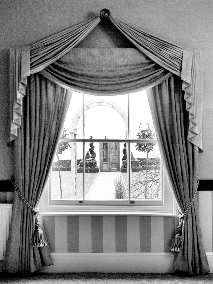 Window with curtains tied back looking out at marquee ceremonial area wedding venue essex