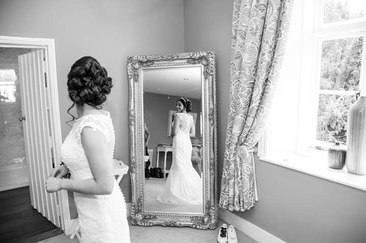 Bride looking in mirror at dress