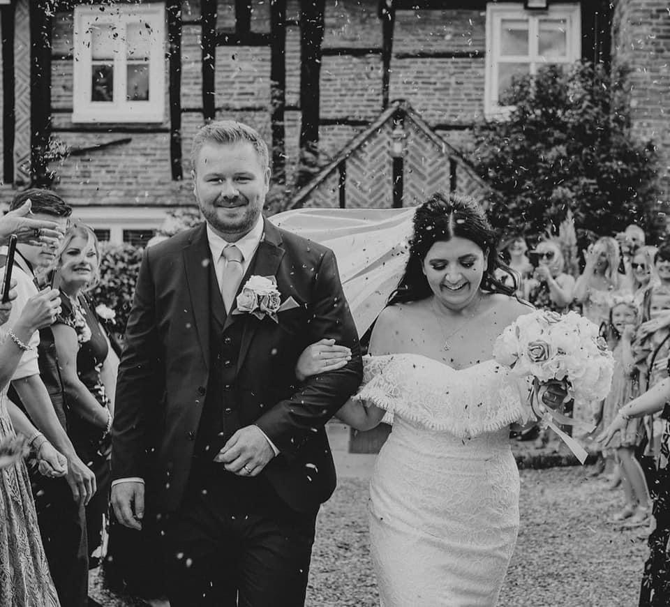 Newlyweds walking down the aisle at Newland Hall wedding venues essex